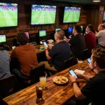 Experience the excitement of sports betting on fabet in a lively bar atmosphere.