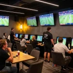 Bettors engaged in sports wagering at a modern lounge with live match displays, keo-nha-cai-vn logo visible.