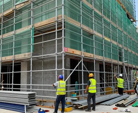 Workers installing commercial scaffolding on a building, ensuring safety and efficiency during renovation.